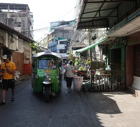 Working street with shops, people and tuk-tuk in Talat Noi.