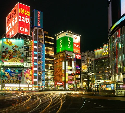 Illuminated east Shinjuku intersection after dark.